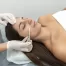 Hispanic female patient with eyes closed in the cosmetic clinic preparing for dermaplaning treatment